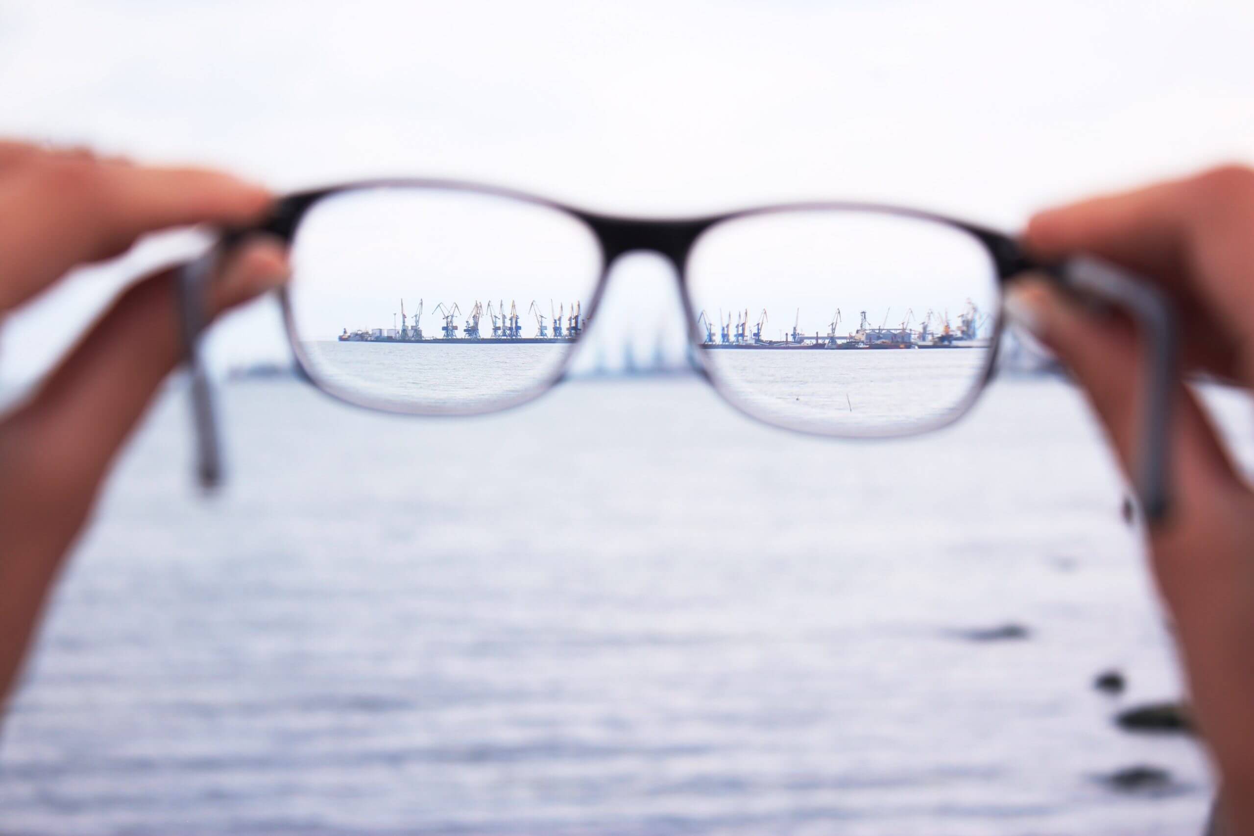 Glasses being held near the sea