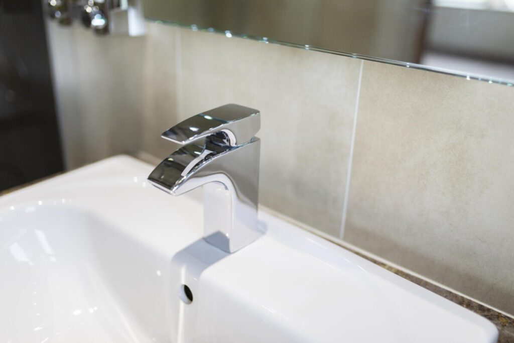 A close up of a chrome modern tap in the bathroom