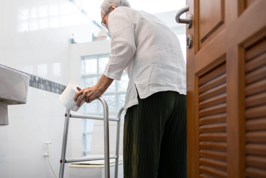elderly person walking towards high toilet