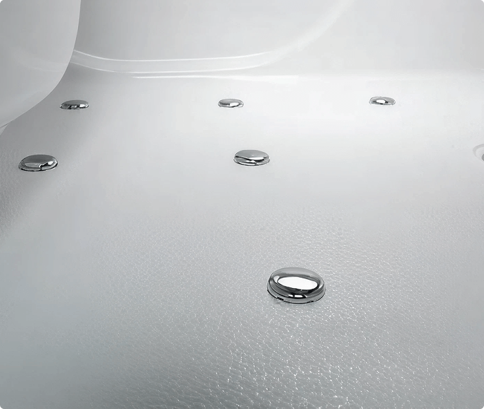 Close-up of the Derwent bath interior, showing discreet chrome spa jets set into a textured white base.