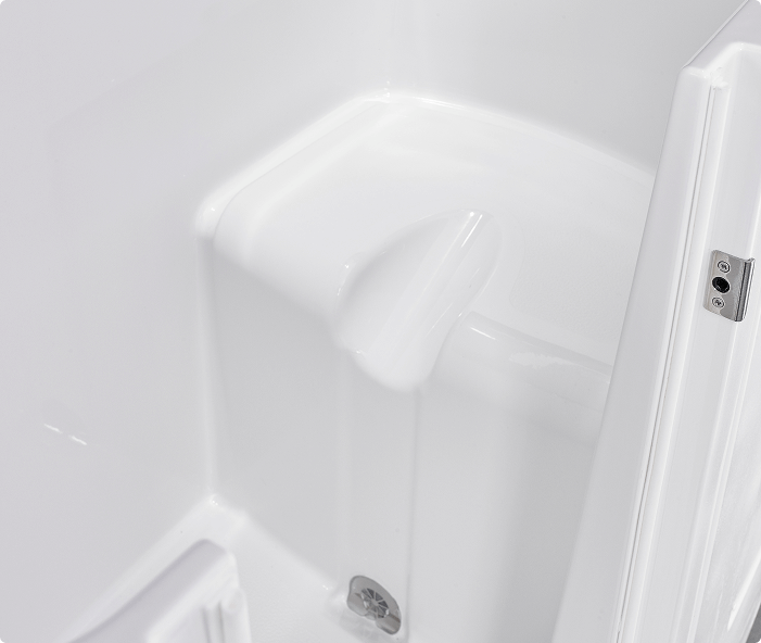 Close-up inside view of the Grasmere walk-in bathtub highlighting the contoured built-in seat, smooth white interior, door hinge, and chrome drain at the base. The design emphasises comfort and safety with spacious seating and easy access.