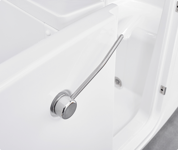 Close-up image of the Grasmere walk-in bathtub door showing the sturdy white door panel and a polished chrome lever handle. The handle is designed for easy grip and secure closure, enhancing safety and accessibility for users entering or exiting the bath. The interior is clean and spacious, with a visible drain at the bottom.