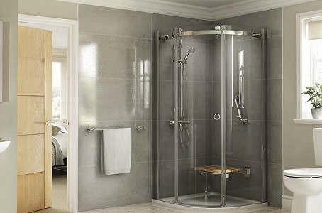 Richmond quadrant walk-in shower with glass panels, wall-mounted seat, and chrome fixtures in a bright, accessible bathroom.
