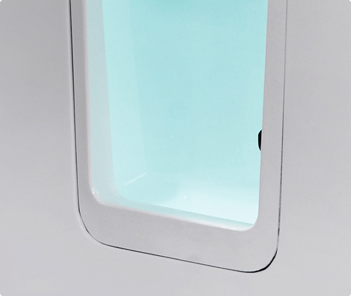 The image shows the walk-in door of the Hampton Elite bath, featuring a clear, inset door with a white frame and aqua-tinted water visible inside. The bath’s clean lines and accessible design highlight its user-friendly features.