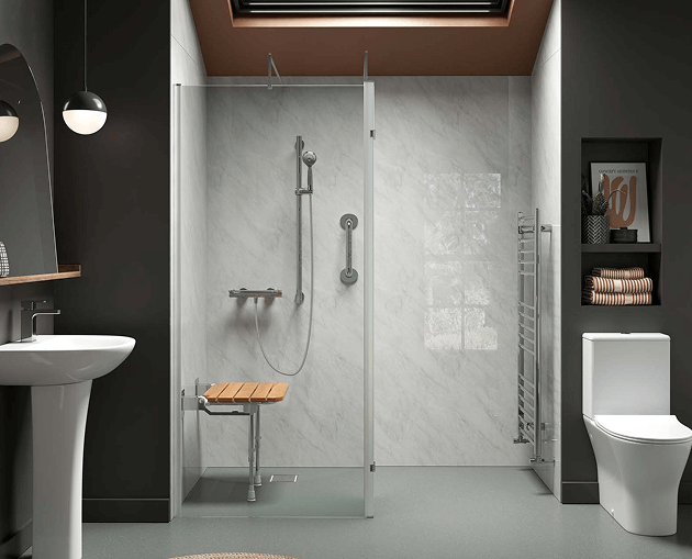 Walk-in shower with wall-mounted wooden seat, grab bar, and handheld shower. Toilet and pedestal sink nearby in modern bathroom.