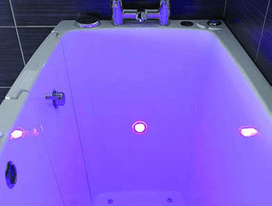 Built-in spa option with glowing purple underwater lights, designed to enhance relaxation in a walk-in bath.