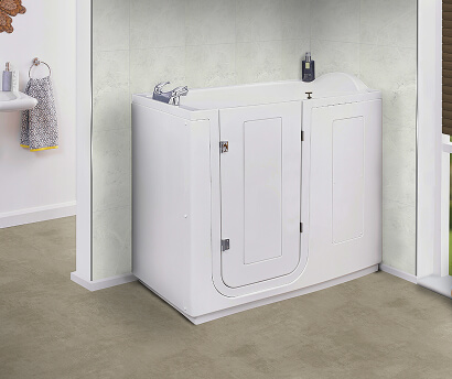 The Grasmere walk-in bath with high sides, inward-opening door and integrated seat, set against pale tiled walls and a soft stone-coloured floor.