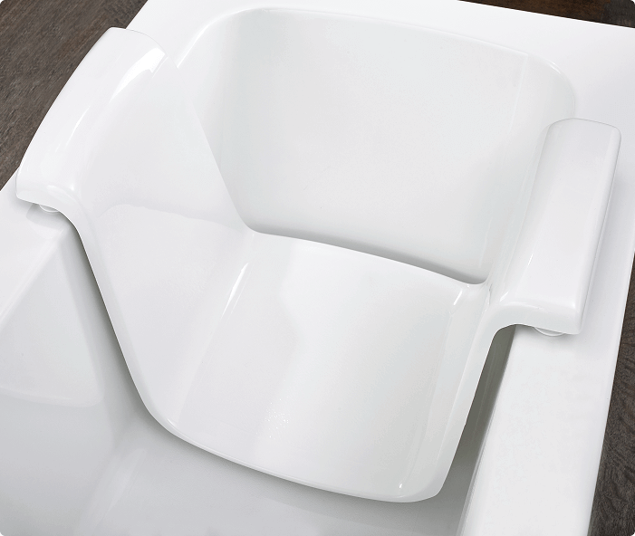 Close-up of contoured white molded seat with armrests, designed for comfort and support inside a walk-in bath.
