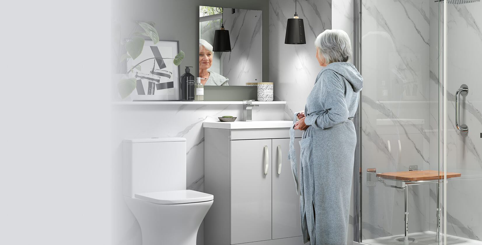 Modern bathroom with walk-in shower featuring fold-down wooden seat and chrome grab bar. Older woman stands at vanity mirror in bathrobe.