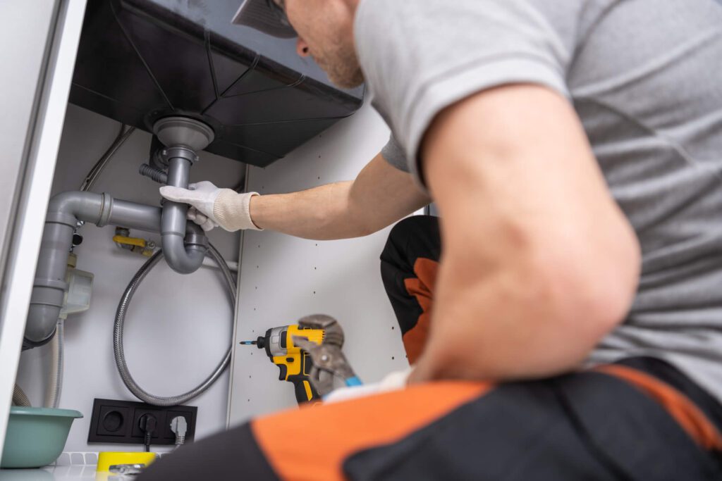 Plumber fixing an issue with pipes.