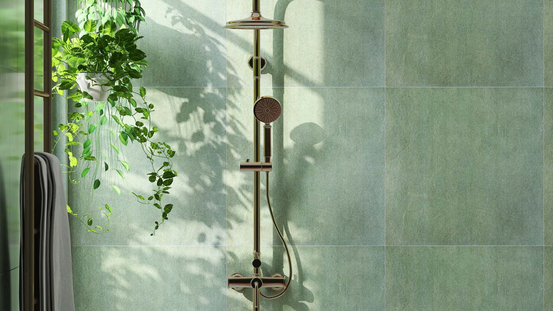 Modern and luxury bathroom design with shiny gold colored rain shower, shower head on slide bar on beautiful green granite wall and creeper plant.